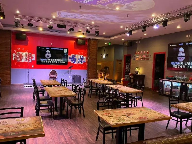 Spacious indoor dining area with stage and red accent wall at NO WINE NO NIGHT, a Chinese Restaurant in Rowland Heights